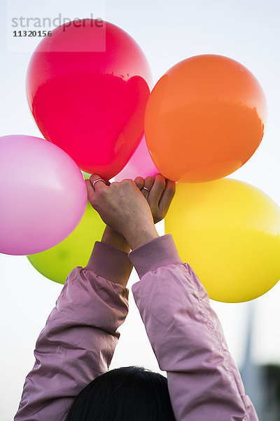 Frau hält Luftballons im Freien