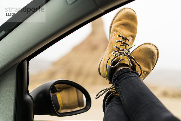 Spanien  Navarra  Bardenas Reales  Beine einer jungen Frau aus dem Autofenster gelehnt