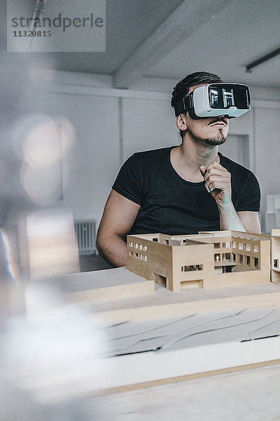 Mann mit Architekturmodell und VR-Brille