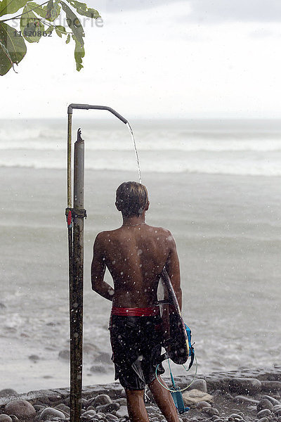 Indonesien  Bali  Surfer beim Duschen im Regen