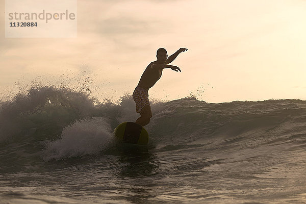 Indonesien  Bali  Surfer bei Sonnenuntergang
