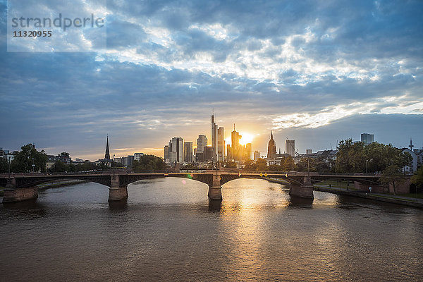 Deutschland  Frankfurt  Blick auf das Finanzviertel bei Sonnenuntergang mit Ignatz-Bubis-Brücke im Vordergrund