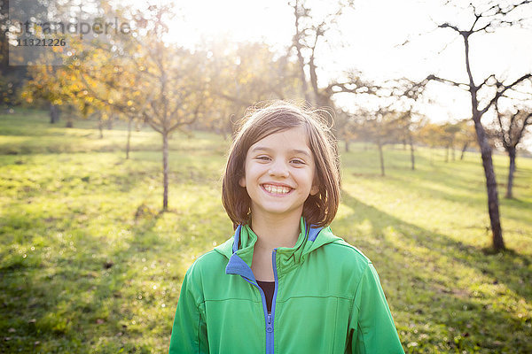 Porträt eines lächelnden Mädchens auf einer Wiese im Herbst
