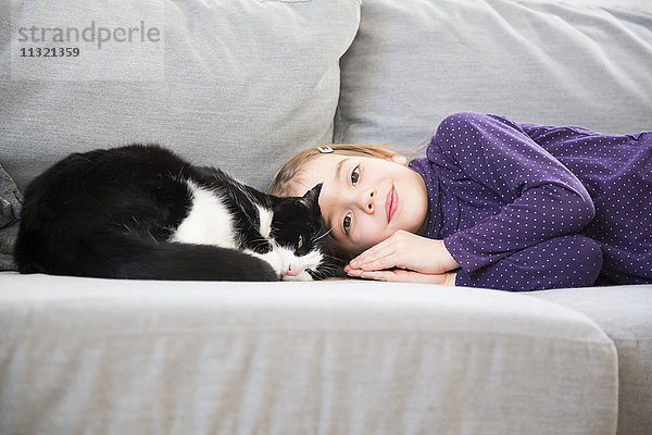 Bildnis eines kleinen Mädchens auf der Couch mit Katze