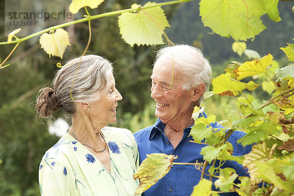 Sicheres Seniorenpaar im Garten stehend