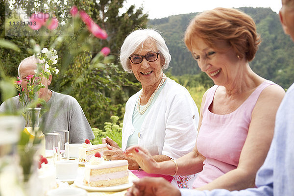 Seniorinnen essen Kuchen im Garten