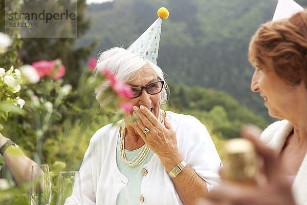 Seniorenfrauen lachen bei der Feier  tragen Partyhüte