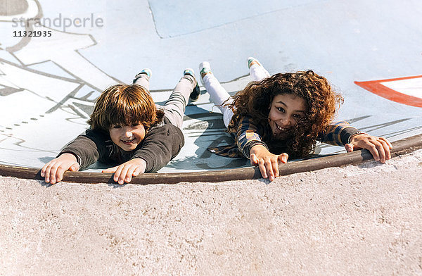 Zwei Kinder spielen im Skatepark
