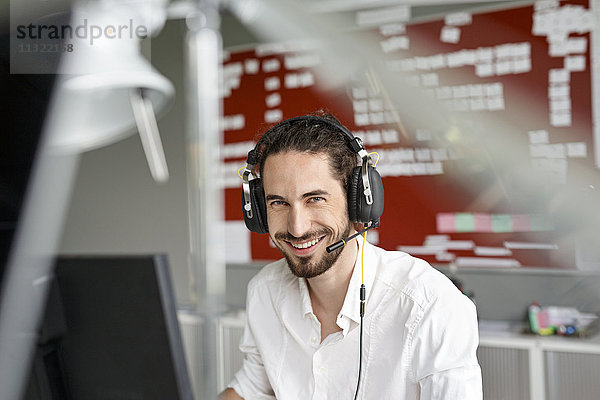 Lächelnder Mann im Büro mit Headset