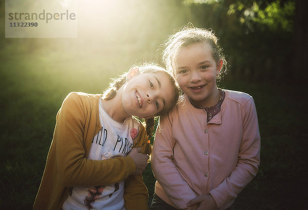 Portrait von zwei kleinen Mädchen im Gegenlicht