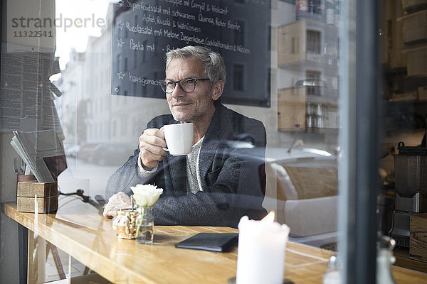 Erwachsener Mann trinkt Kaffee in einem Cafe