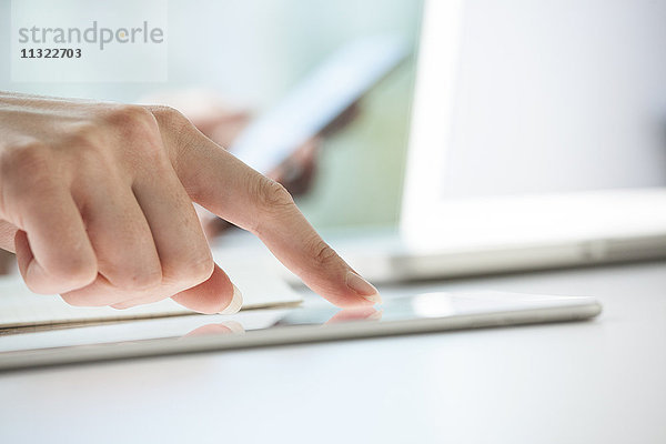 Nahaufnahme der Frauenhände mit Hilfe eines digitalen Tabletts