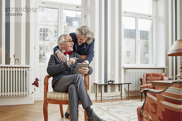 Glückliches Seniorenpaar mit Tablette zu Hause
