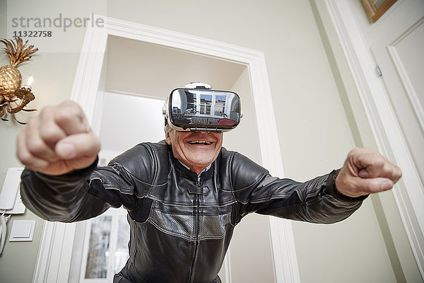 Senior im Motorradanzug mit VR-Brille