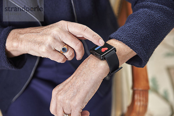Seniorin überprüft medizinische Daten auf smartwatch