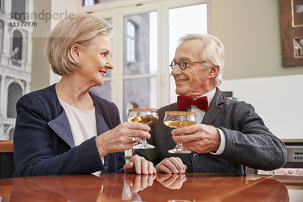 Lächelndes älteres Paar klirrende Champagnergläser