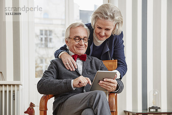 Lächelndes Seniorenpaar mit Tablette