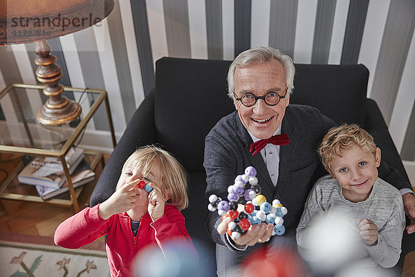 Großvater und Enkelkinder mit molekularem Modell