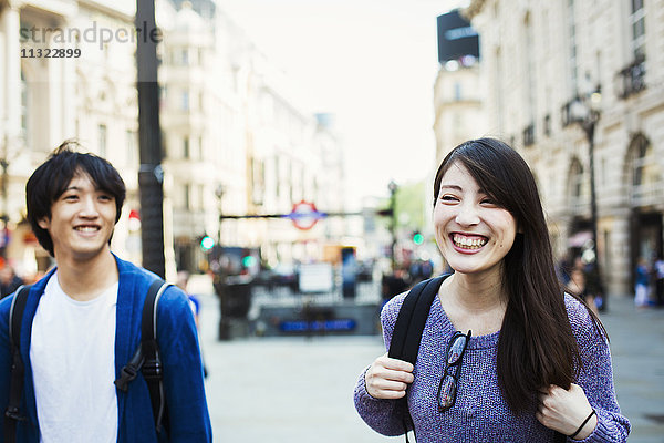 Ein junger Japaner und eine junge Japanerin genießen einen Tag in London bei einem Spaziergang in der Nähe des Piccadilly Circus.