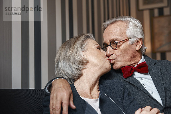 Seniorenpaar beim Küssen auf der Couch
