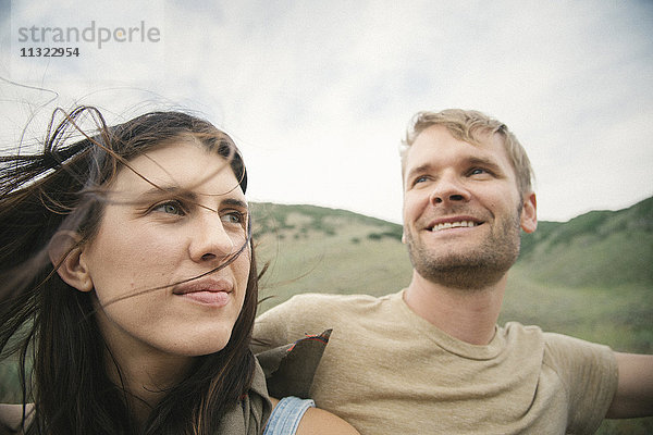 Ein lachendes Ehepaar auf einer Autoreise in den Bergen.