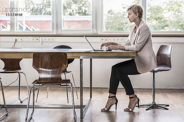 Geschäftsfrau mit Laptop im modernen Konferenzraum