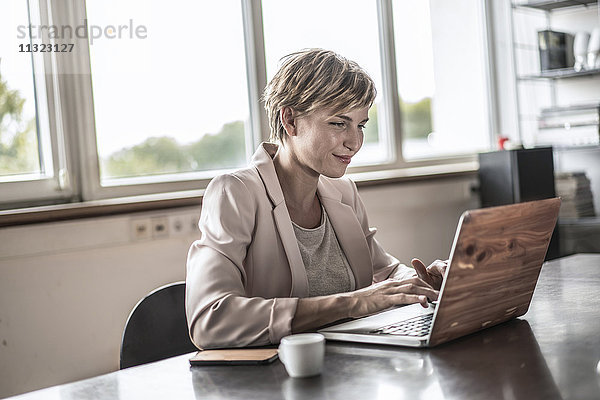 Geschäftsfrau mit Laptop im Konferenzraum