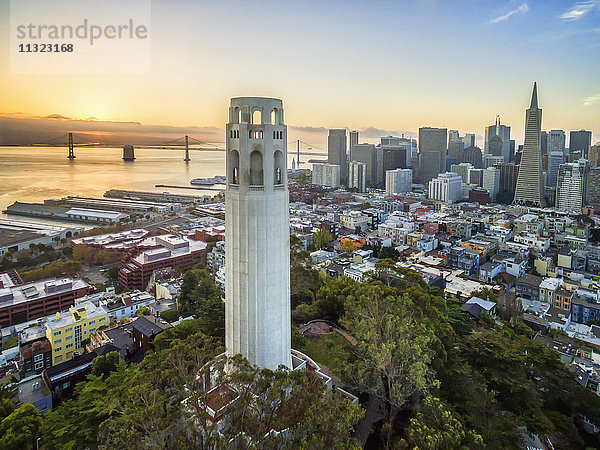 Der Coit-Turm  ein Art-Déco-Denkmal im Stadtteil Telegraph Hill von San Francisco. Luftaufnahme bei Sonnenuntergang über der Stadt San Francisco.