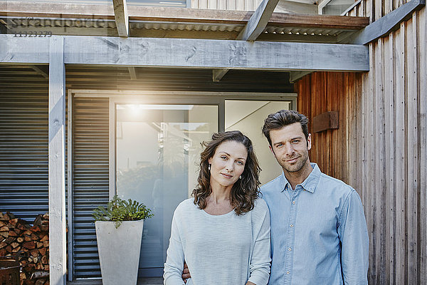 Paar steht vor der Tür ihres Hauses