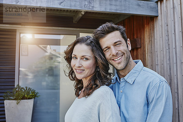 Paar steht vor der Tür ihres Hauses