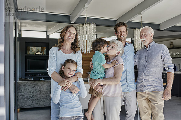 Mehrgenerationen-Familie steht im Einfamilienhaus
