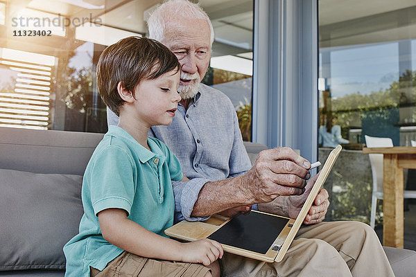 Großvater und Enkelzeichnung auf Laptop-Tafel