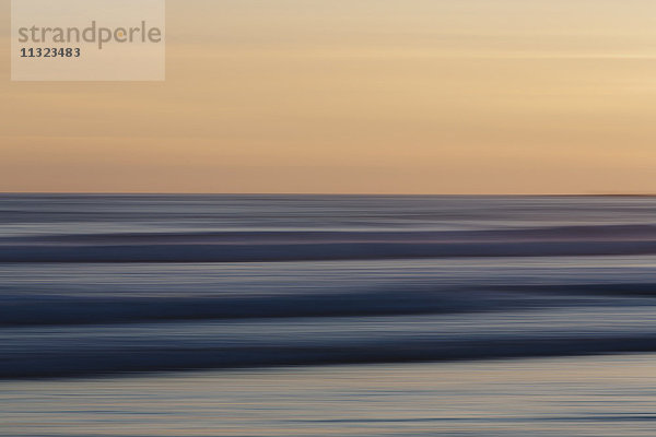 Blick vom Strand über den Ozean bei Sonnenuntergang  lange Exposition