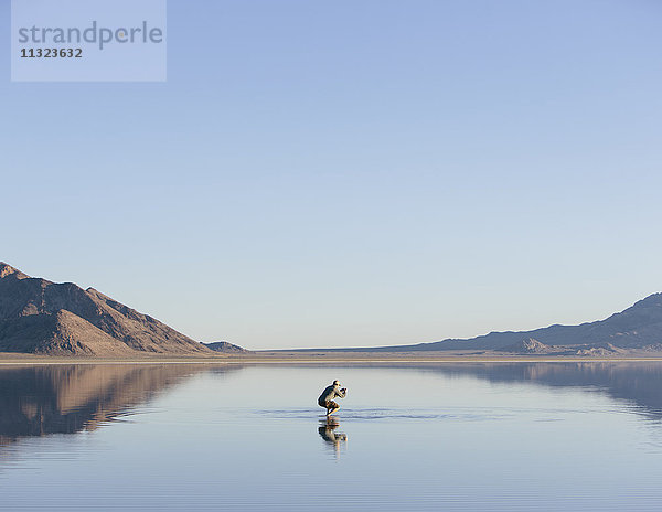 Mann geht über die riesigen und überfluteten Bonneville Salt Flats  Utah