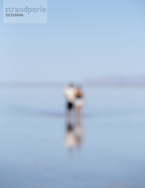 Unscharfes Bild von zwei Personen  die auf überfluteten Bonneville Salt Flats  Utah  stehen