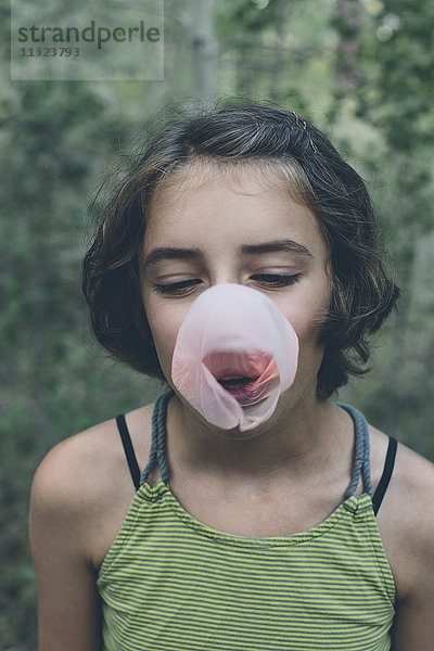Elfjähriges Mädchen bläst Kaugummiblase