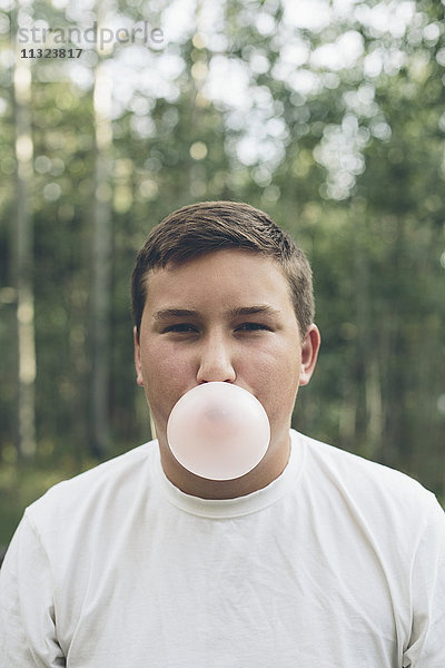 Porträt eines Teenagers  der Kaugummiblasen bläst