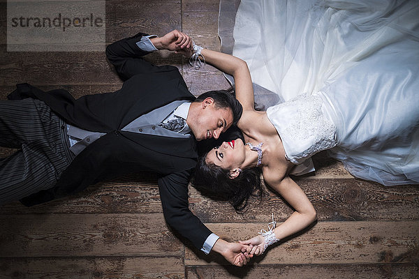 Brautpaar auf Holzboden liegend