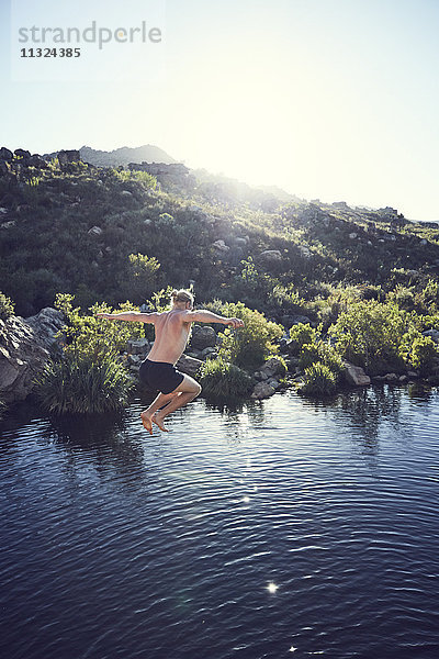Südafrika  Porterville  Beaverlac  Mann beim Sprung ins Wasser