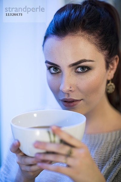 Porträt einer jungen Frau mit Teeschale