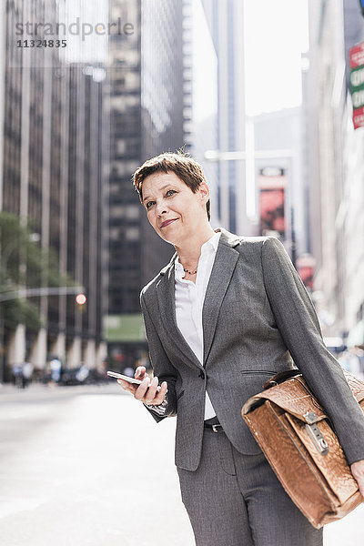 USA  New York City  Geschäftsfrau in Manhattan mit Handy
