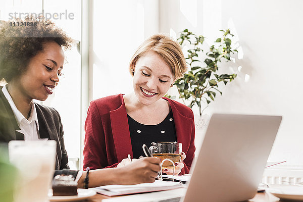 Zwei junge Frauen  die in einem Café arbeiten.