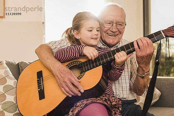 Großvater und Enkelin beim gemeinsamen Gitarrespielen