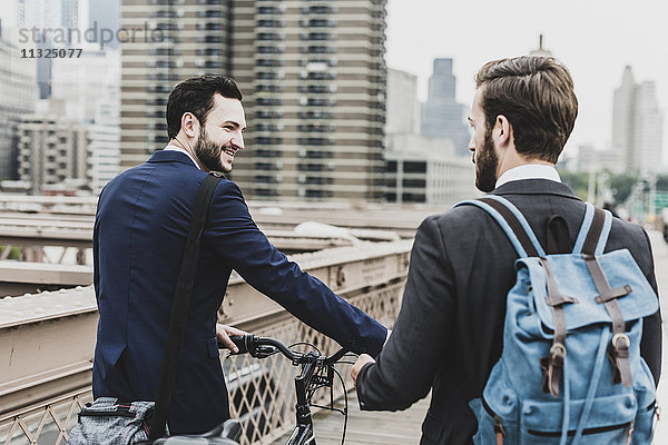 USA  New York City  zwei Geschäftsleute mit Fahrrad auf der Brooklyn Bridge