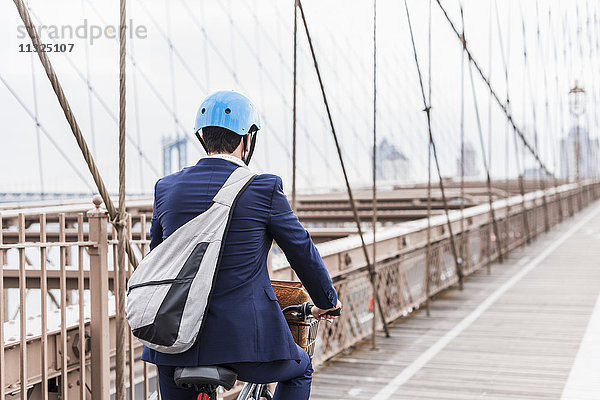 USA  New York City  Mann auf dem Fahrrad auf der Brooklyn Bridge
