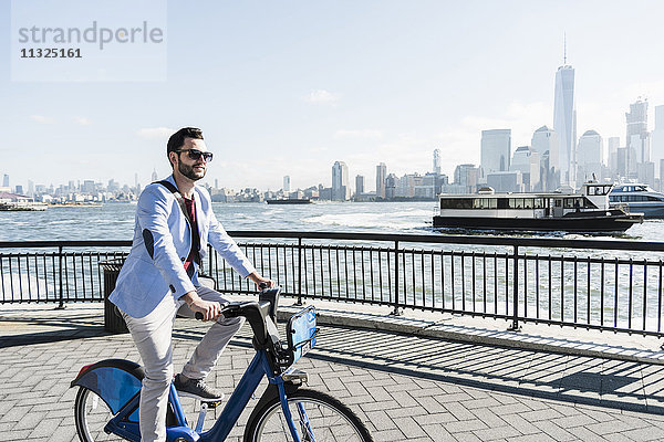 USA  Mann auf dem Fahrrad an der New Jersey Waterfront mit Blick auf Manhattan