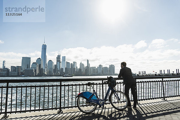 USA  Mann mit Fahrrad am New Jersey Waterfront mit Blick nach Manhattan