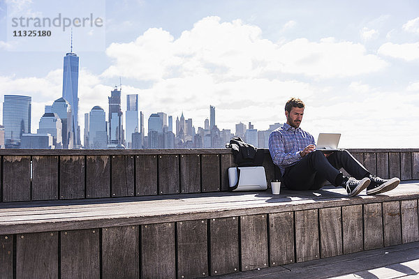 USA  Mann mit Tablette am New Jersey Waterfront mit Blick auf Manhattan