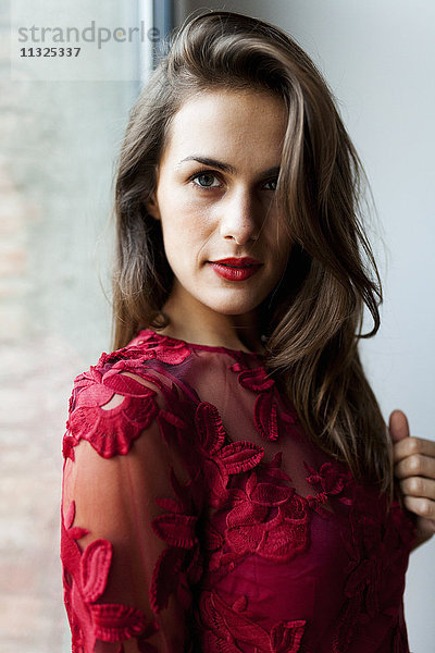 Porträt einer schönen jungen Frau in rotem Kleid