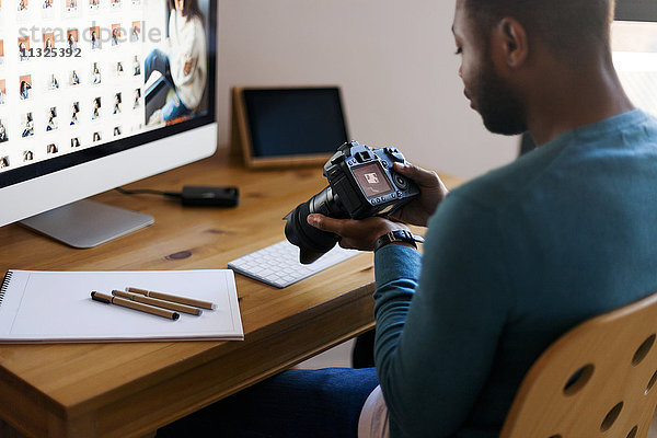 Junge Fotografin bearbeitet Bilder am Schreibtisch